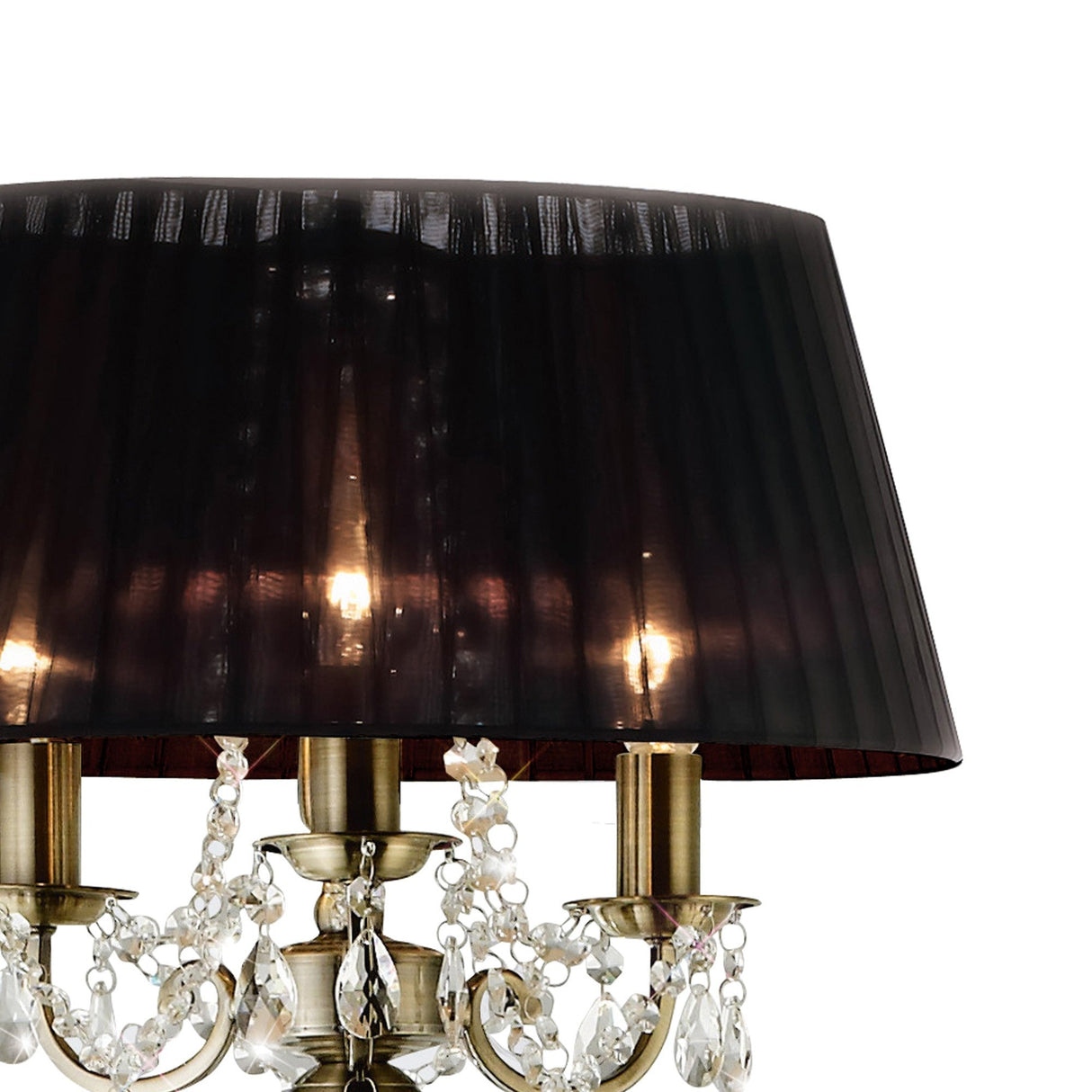 A close-up of the Olivia 3 Light Crystal Floor Lamp—featuring a brass finish, black shade, and hanging crystals—glows warmly, highlighting its refined elegance and sophisticated charm.