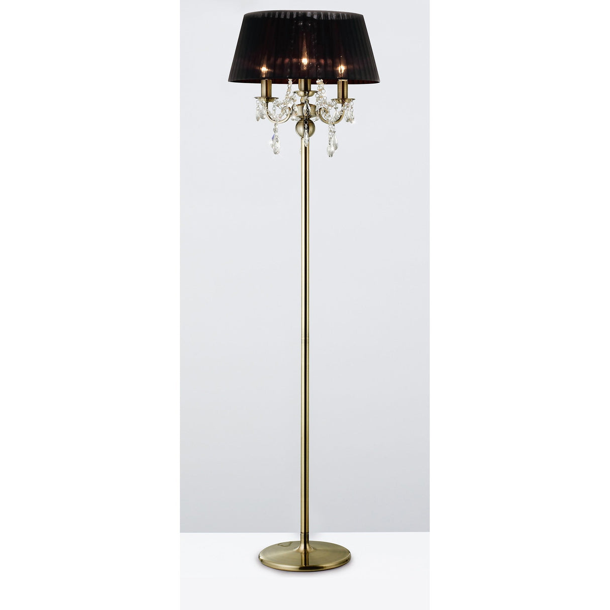 The Olivia 3 Light Crystal Floor Lamp features an antique brass finish, a round base, black pleated shade, and elegant hanging crystal accents below the shade.