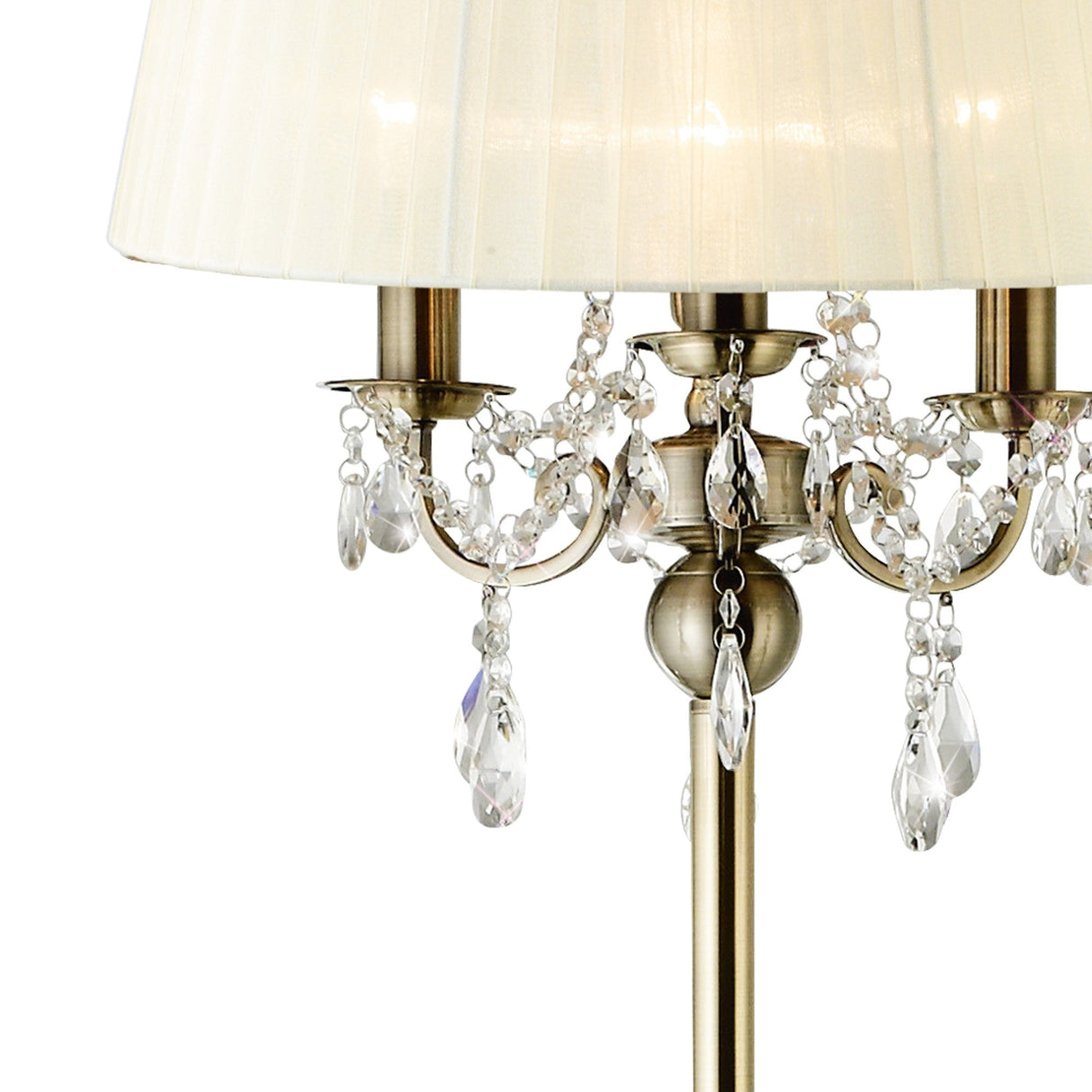 A close-up of the Olivia 3 Light Crystal Floor Lamp in brass with a cream shade, featuring elegant crystal ornaments and hanging beads that reflect light beautifully.
