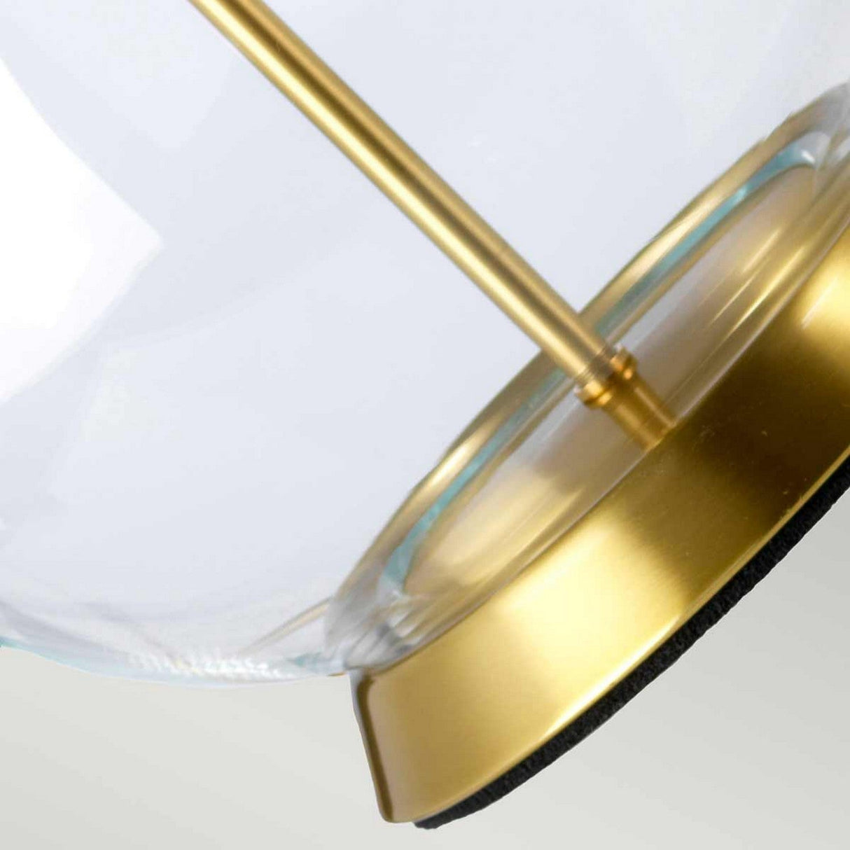 Close-up of the Orb 1 Light Table Lamp, showcasing its elegant design with a clear glass shade and a slender aged brass stand on a round base. This blend of contemporary and classic styles captures the essence of an aged brass table lamp.