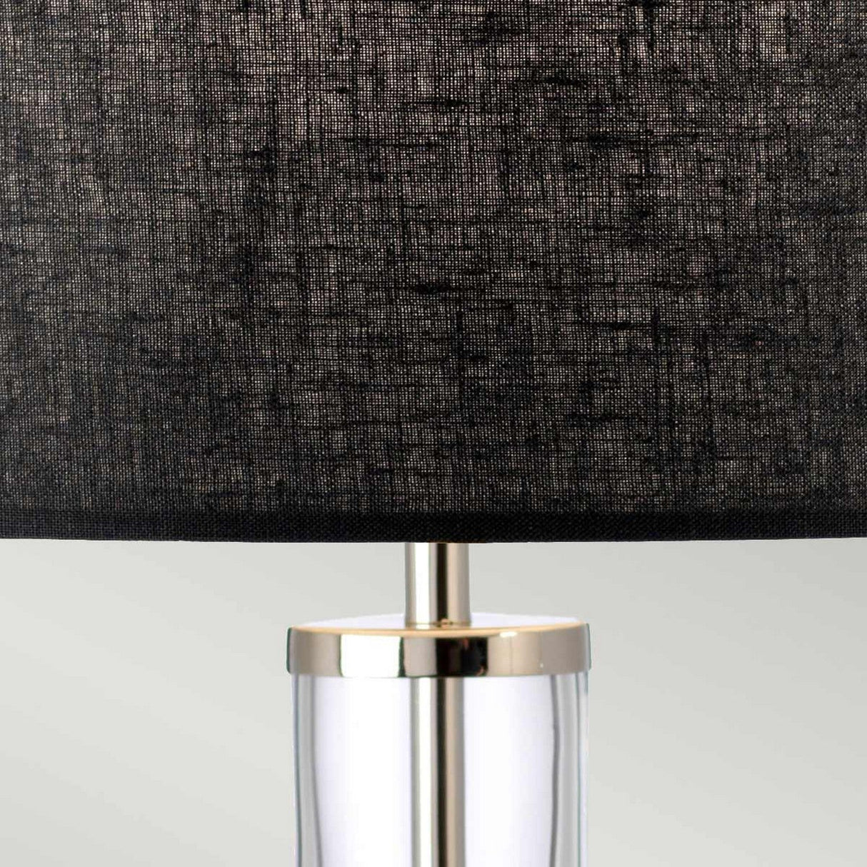 Close-up of the Orb 1 Light Table Lamp, showcasing its textured black shade and transparent glass base, highlighted with a polished nickel accent at the top.