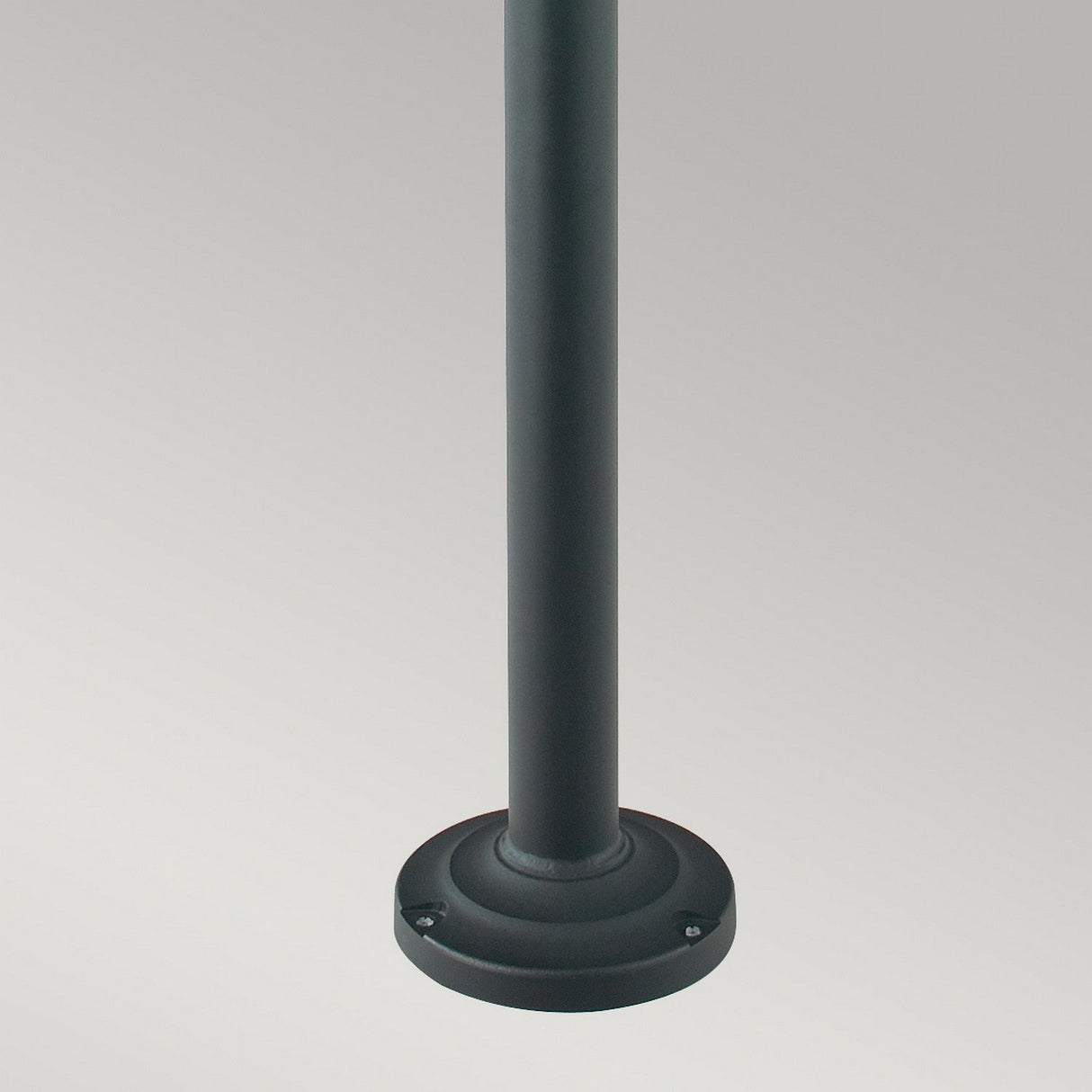 Close-up of a dark, cylindrical Oslo 2 Light Lamp Post - Black mounted on a round base against a plain background, used in exterior lighting.