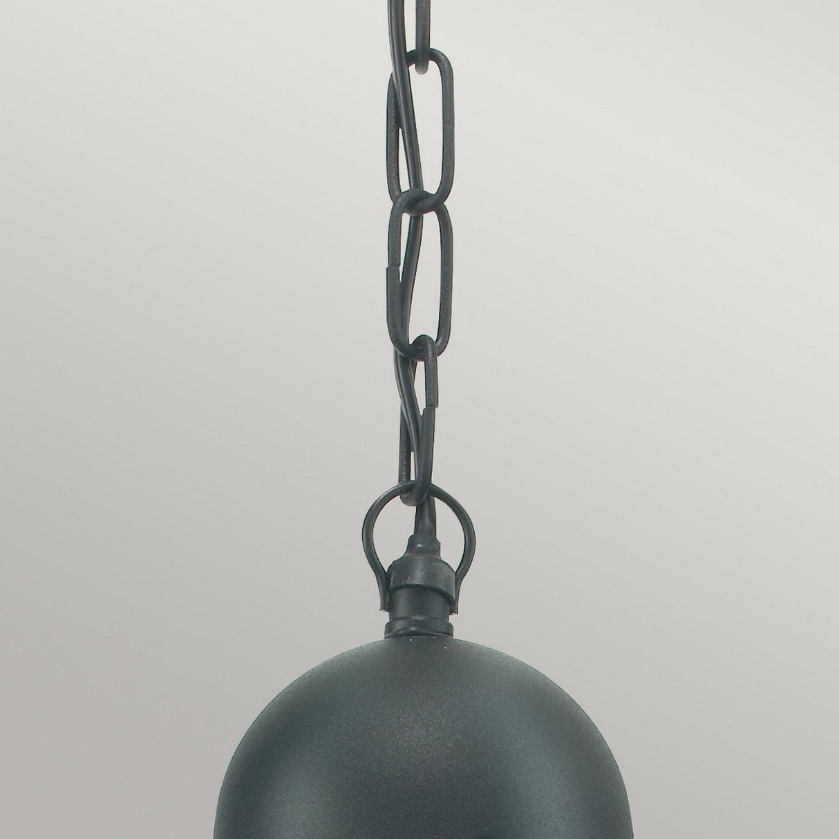 A close-up of the Oslo Outdoor 1 Light Chain Pendant in black showcases its round metal shade in galvanized steel and chain link attachment against a light gray background, reflecting sleek Scandinavian design.