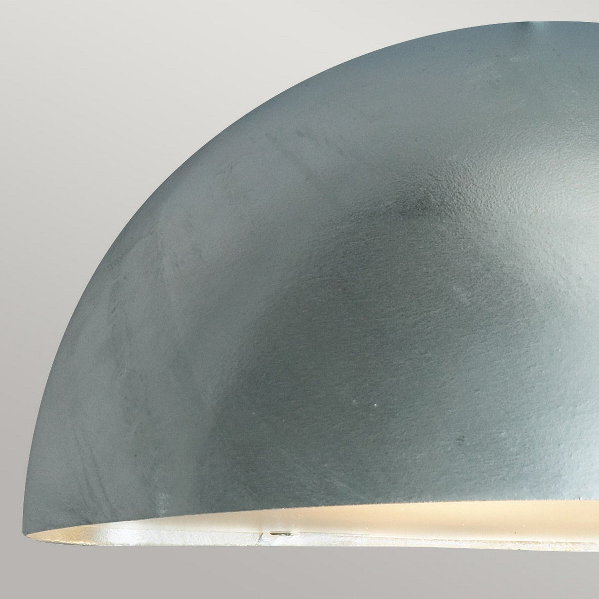 Close-up of a dome-shaped metallic lamp shade in a matte gray finish, set against a light gray background. The edge reveals a warm white interior and features an IP43 rating, suggesting its modern and minimalistic design can rival the sleek silver finish of the Paris Outdoor Large 1 Light Wall Lantern.