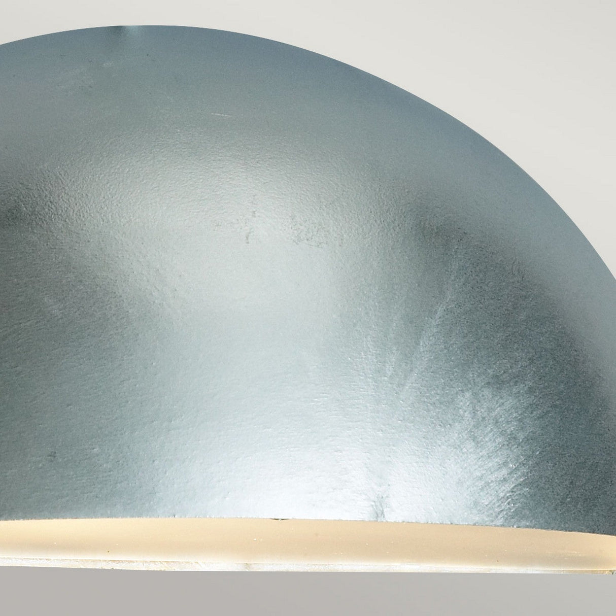 Close-up of the Paris Outdoor Large 1 Light Wall Lantern in a sleek, metallic dome shape with a smooth, reflective silver finish. It emits a gentle glow against a neutral background and features an IP43 rating for dependable use in diverse environments.