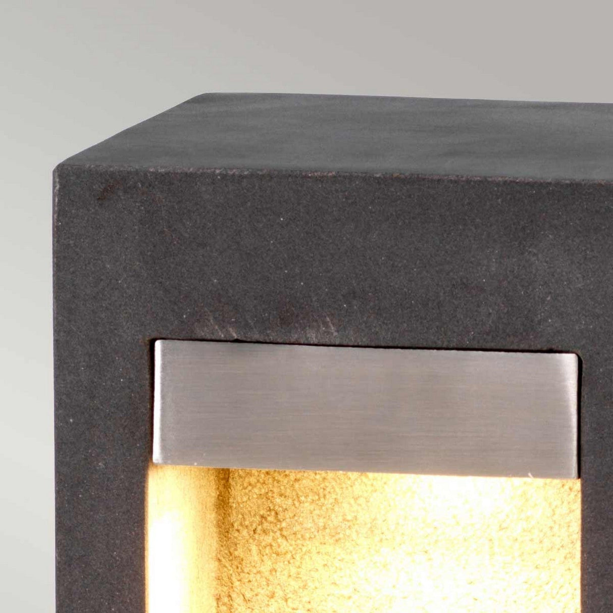 Explore the Parkstone Medium LED Bollard, designed with a modern cubic shape crafted from dark basalt stone. This sophisticated light features LED illumination, producing a warm yellow glow. Its flat top is complemented by a horizontal stainless steel strip on the front, making it an ideal choice for upscale outdoor lighting solutions.