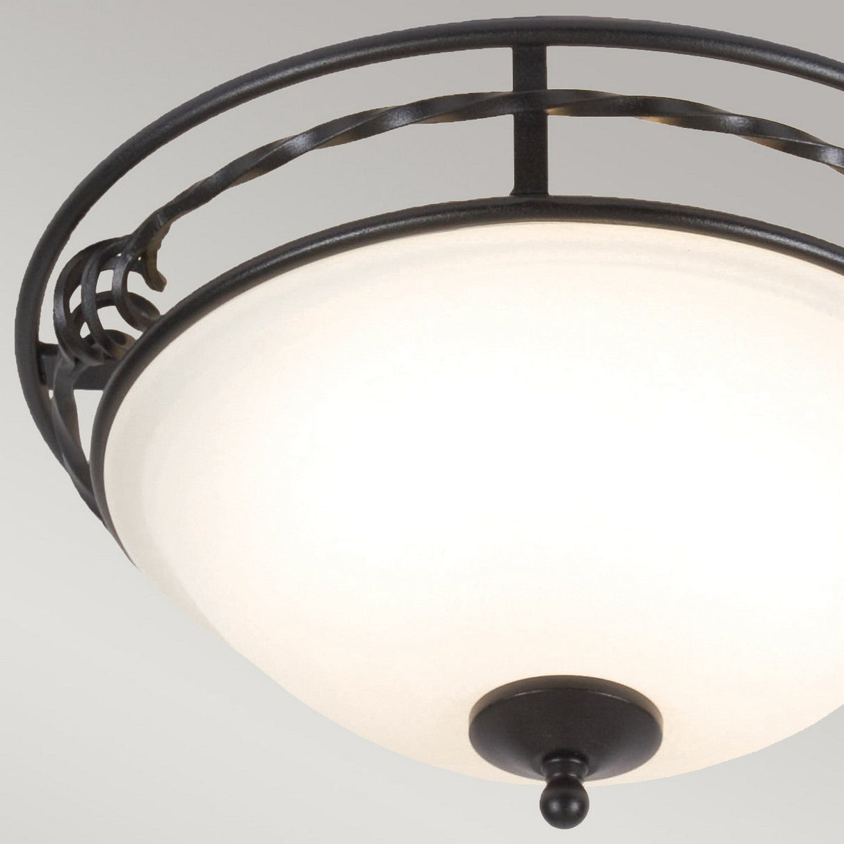 The Pembroke 2 Light Flush Light - Black is a round, white, flush-mount ceiling fixture featuring a sleek twisted design in a dark bronze metal frame and accented by a small finial at the bottom. Its elegance stands out against the plain gray background.