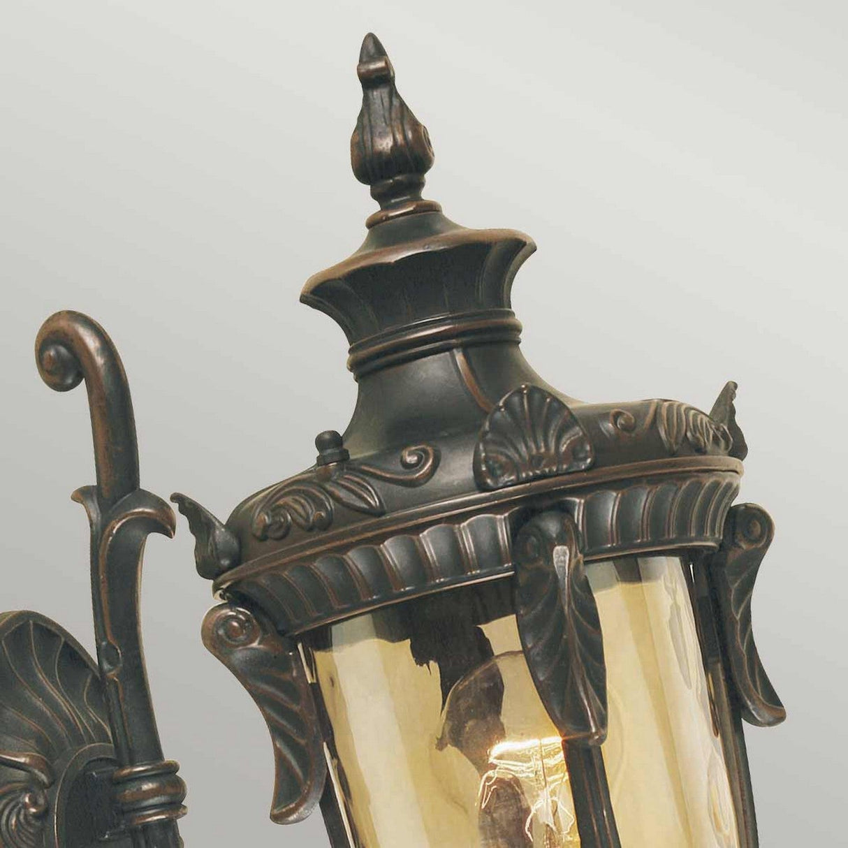 Close-up of the Philadelphia 1 Light Outdoor Small Wall Light in old bronze, showcasing vintage-style intricate metalwork and a glass enclosure. It features decorative scrolls and ornate designs, adding an elegant touch to this period-inspired outdoor lantern.