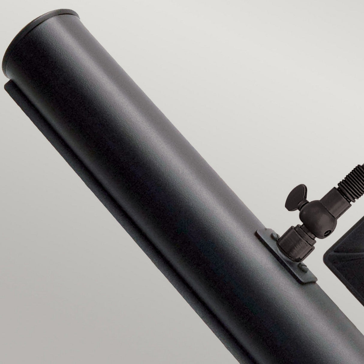 Close-up of the Picture Light 2 Light Large - Black against a grey background, highlighting its attached knob and small angled support, reminiscent of adjustable lighting used for precise artwork illumination.