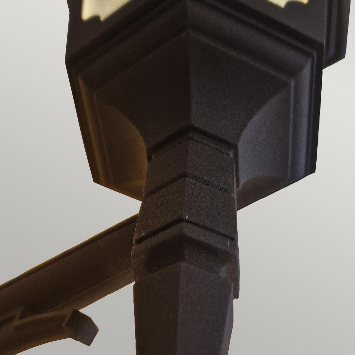 A close-up of the Parish 1 Light Outdoor Down Wall Light in black features a vintage-style lamp post with a lantern top set against a muted backdrop. Made from die-cast aluminum, this lantern showcases geometric patterns and is finished with a black powder coating, epitomizing classic outdoor design.