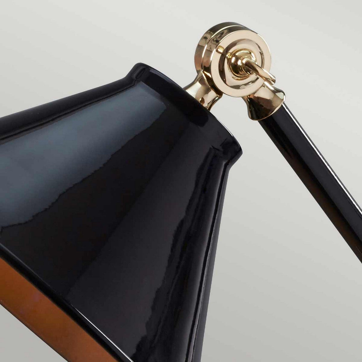 Close-up of the Provence Element 1 Light Mini Table Lamp in Black/Polished Brass, showcasing a French-inspired design. The sleek metal arm and glossy shade elegantly reflect light against a neutral, light background.