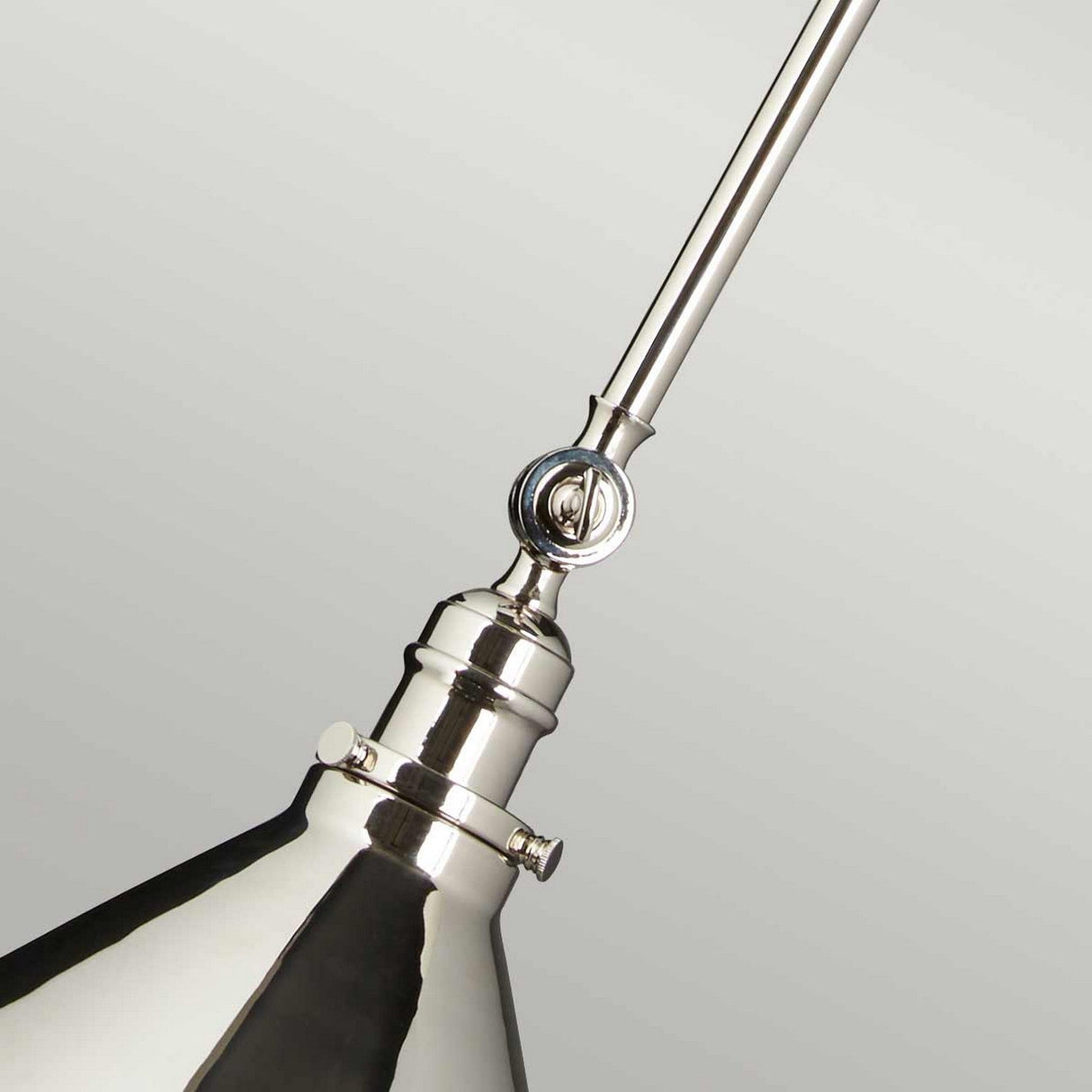Close-up of the Provence 1 Light Wall Light/Pendant in polished nickel, featuring a conical shade. Its design incorporates a pivoting joint and a slender arm, highlighting its sleek and modern aesthetic against a plain background.
