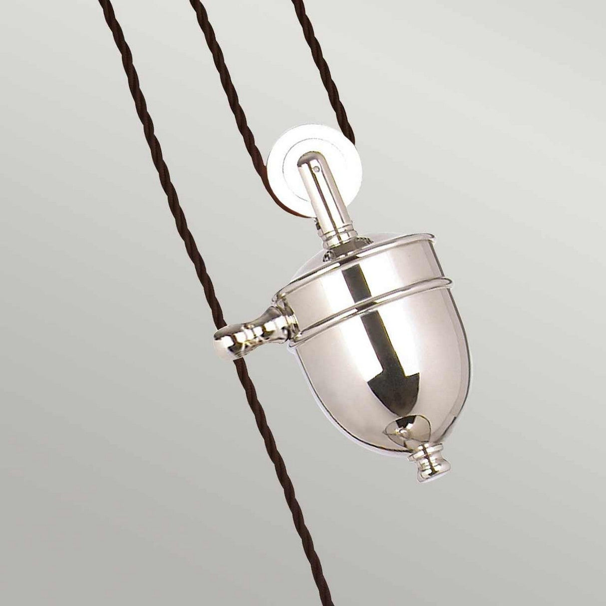 The Provence 1 Light Rise & Fall Pendant in polished nickel features a reflective surface and hangs from a twisted dark cord against a light background. This adjustable pendant light showcases a unique, rounded, industrial design that is both striking and versatile.
