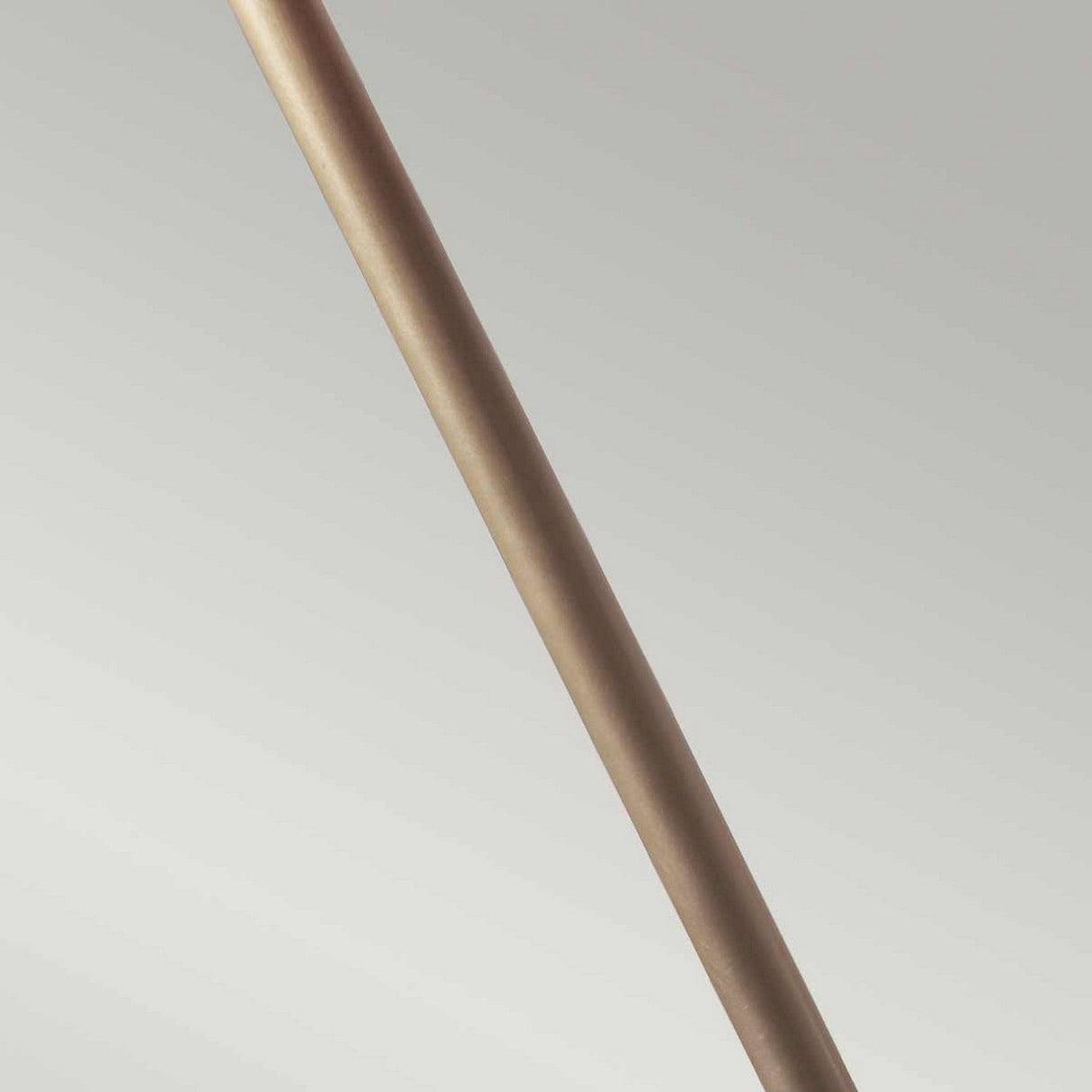 A close-up of the Provence 1 Light Stick Lamp in aged brass, a slender, metallic rod with a French design and smooth, reflective surface, positioned diagonally against a plain, light gray background.