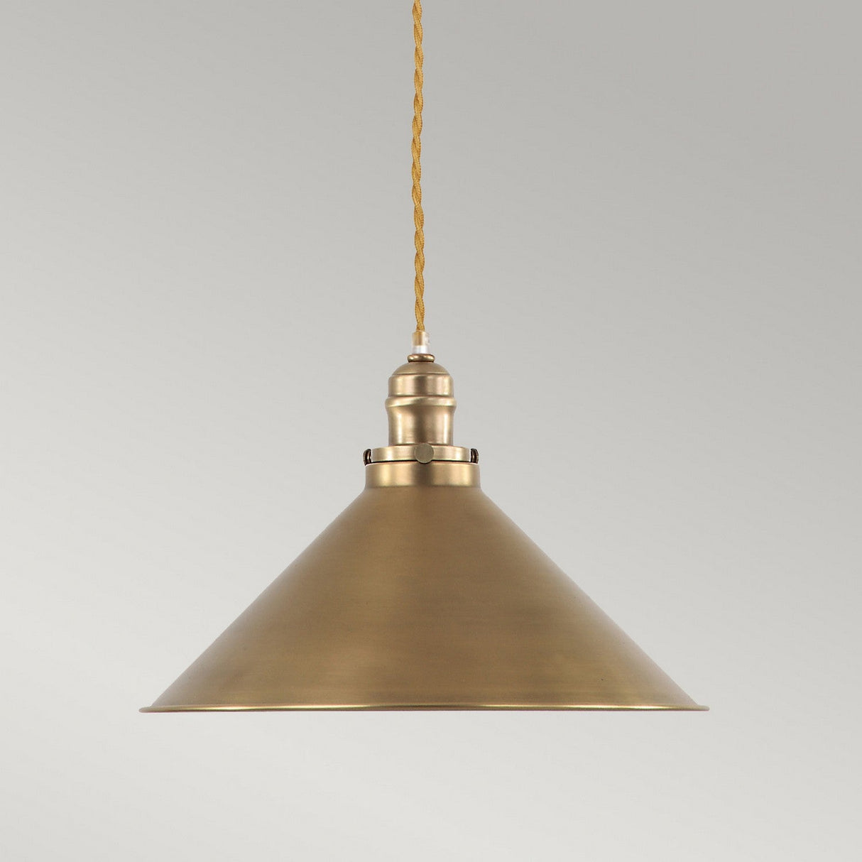 The Provence 1 Light Pendant - Aged Brass features a cone-shaped design with a rustic finish, suspended from an adjustable yellow twisted cord against a light gray background, perfectly embodying vintage lighting charm.