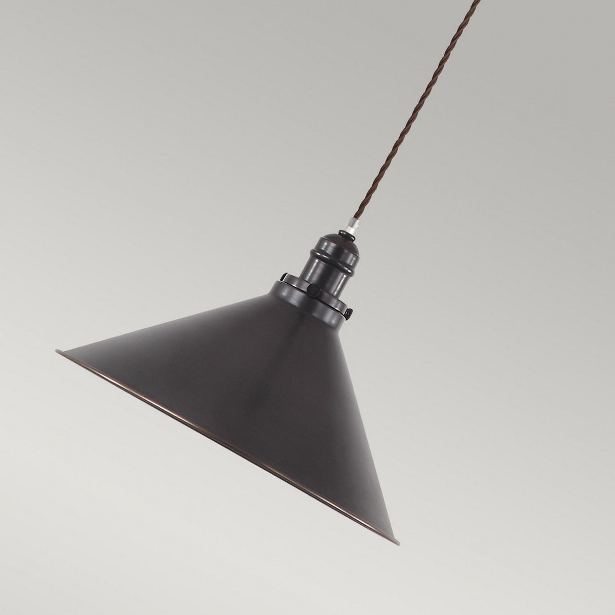 The Provence 1 Light Pendant in Old Bronze showcases a vintage charm with its black, cone-shaped design and twisted cord, elegantly suspended from the ceiling against a neutral gray backdrop.
