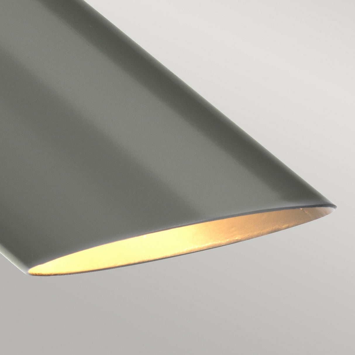 Close-up of the Quinto 1 Light Table Lamp, featuring a sleek and minimalist design with a smooth, cylindrical shape. When turned on, the modern dark grey and polished nickel finish adds an elegant touch by casting a warm glow from the bottom against a neutral background, making it perfect for industrial-style interiors.