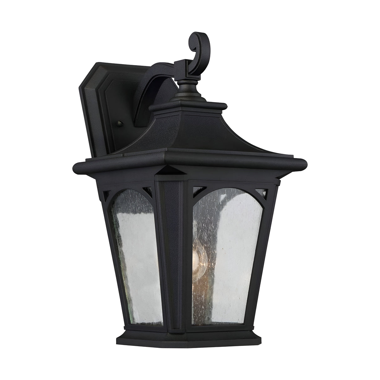The Bedford Outdoor 1 Light Medium Wall Lantern - Black features a traditional black design with a curved top and clear seedy glass panels that reveal the bulb inside. This durable outdoor lighting fixture is mounted on a square backplate, making it an ideal choice for exterior use.