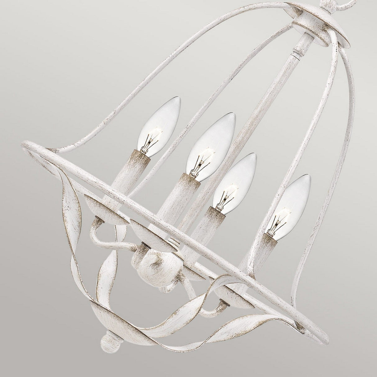 The Bradbury 4 Light Chandelier in Antique White exudes vintage charm with its distressed finish and four-light design. The candle-shaped bulbs are elegantly arranged in a circular pattern, enhanced by gracefully curved ornamental details.