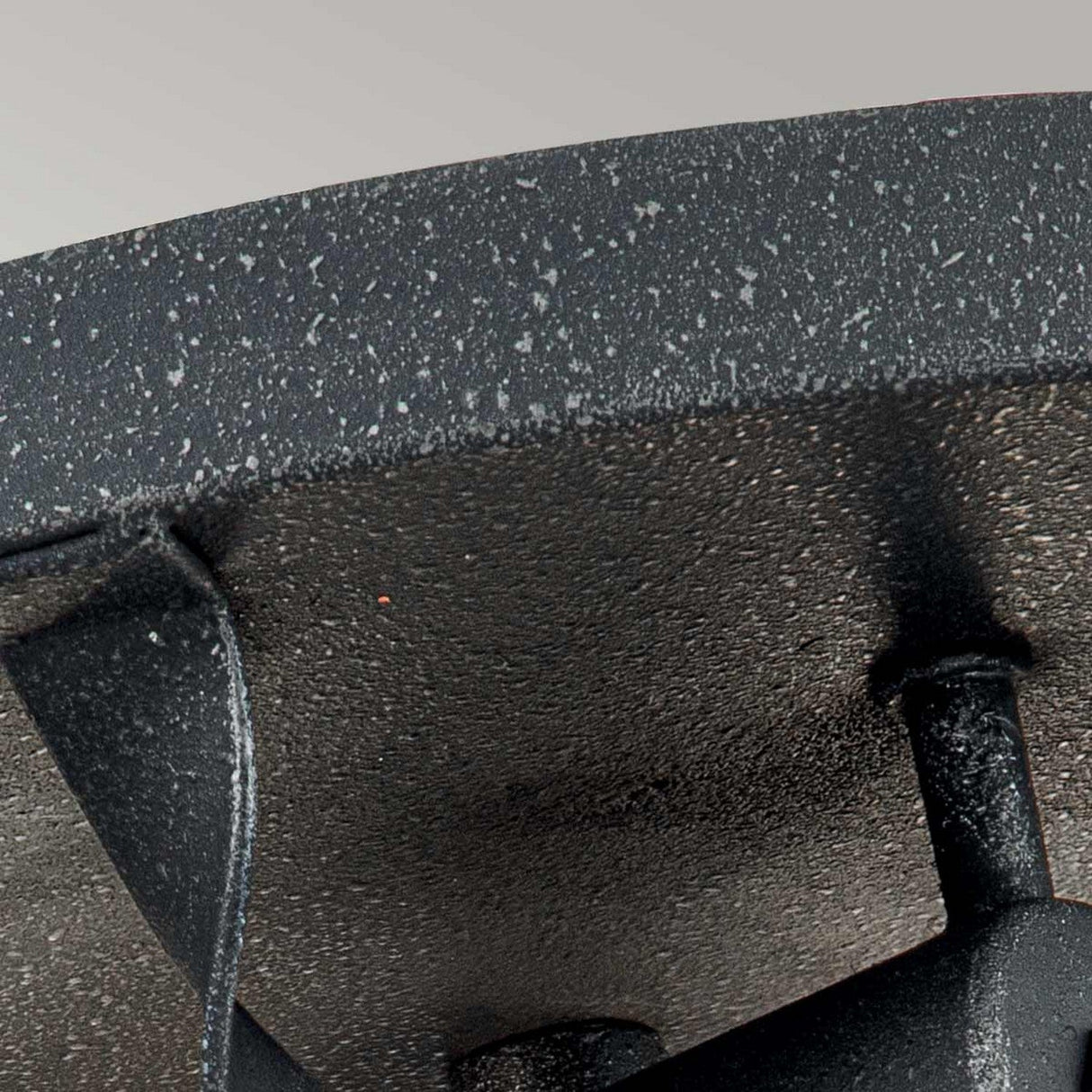 A close-up of the Bradbury 2 Light Flush in Grey Ash highlights its textured, speckled grey ash finish and prominent handle against a light gray background, drawing attention to the intricate surface details and structure.