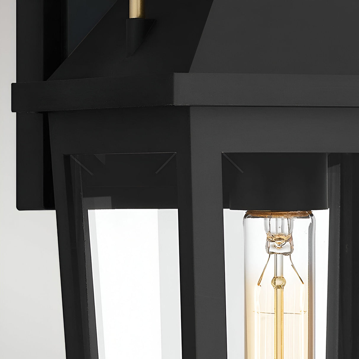 Close-up of the Buckley 1 Light Coastal Medium Outdoor Wall Lights Lantern in black, featuring clear glass panels and a visible filament bulb for stylish, weatherproof outdoor lighting.