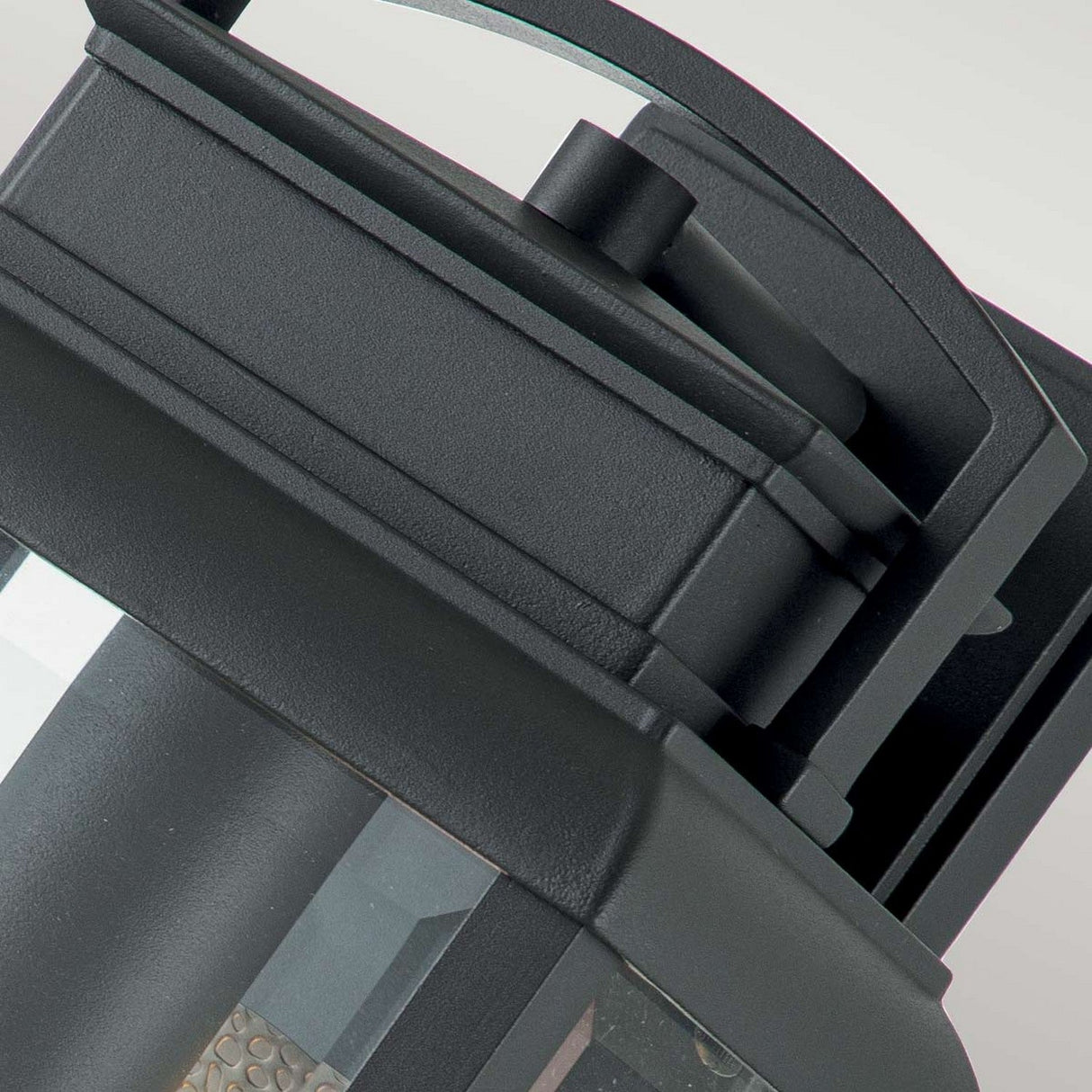 Close-up of the Byron Outdoor 1 Light Medium Wall Lantern in a sleek graphite finish with a grey reflector. Its modern rectangular shape and glass panel form clean lines, offering a sophisticated and contemporary look that complements any exterior space.