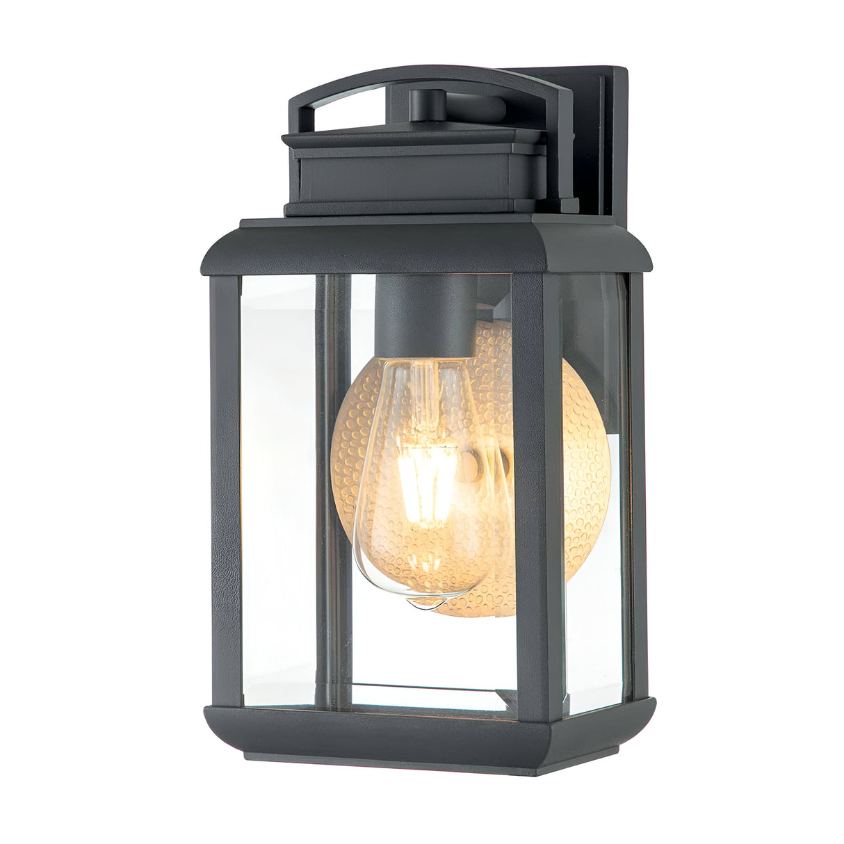 A close-up of the Byron Outdoor 1 Light Small Wall Lantern in a sleek graphite finish, featuring a vintage-style clear glass bulb. This IP44-rated lantern showcases a rectangular design with clear glass panels and a textured backplate, casting a warm glow.
