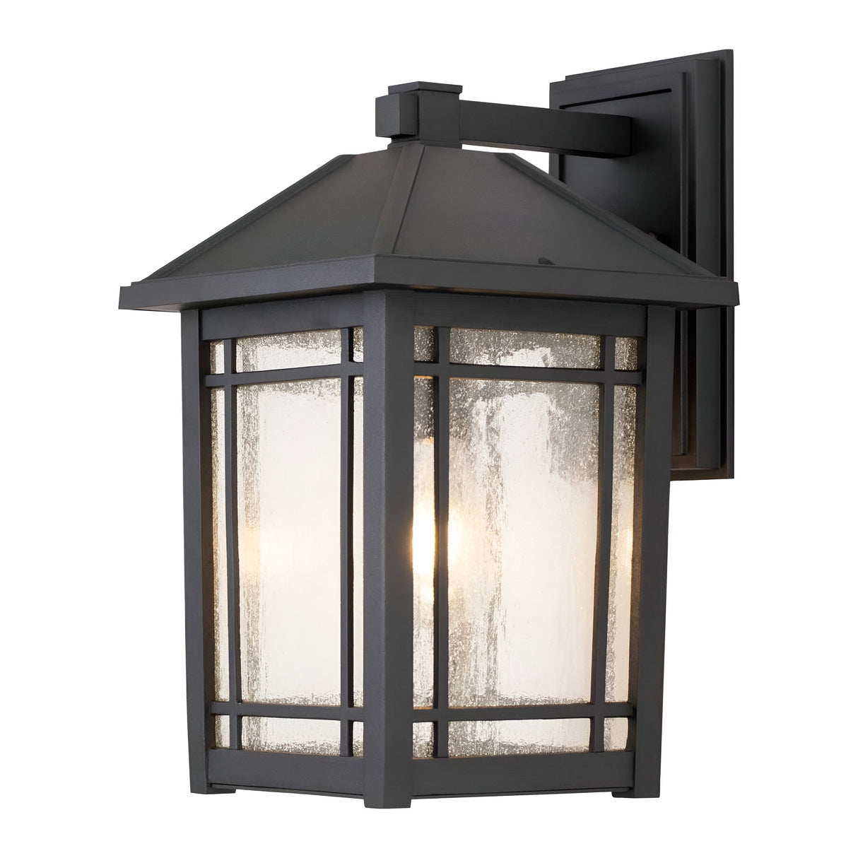 The Cedar Point Outdoor 1 Light Large Wall Lantern in black boasts an IP44 rating, featuring a traditional rectangular frame with glass panels. The bulb inside casts a warm glow, illuminating the textured glass beautifully. It is mounted on a coordinating black square base to ensure a cohesive appearance.