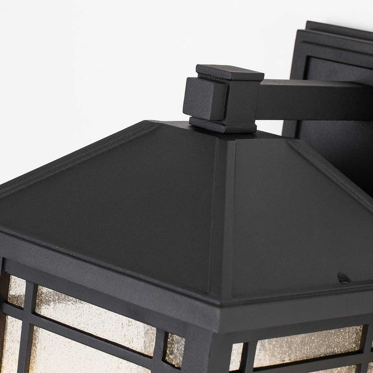 Take a closer look at the Cedar Point Outdoor 1 Light Large Wall Lantern in Black. Featuring a square top and grid-patterned glass panels, its sleek metal frame offers IP44-rated durability when mounted on a wall. The lantern’s slightly textured glass brings an understated charm to any outdoor space.
