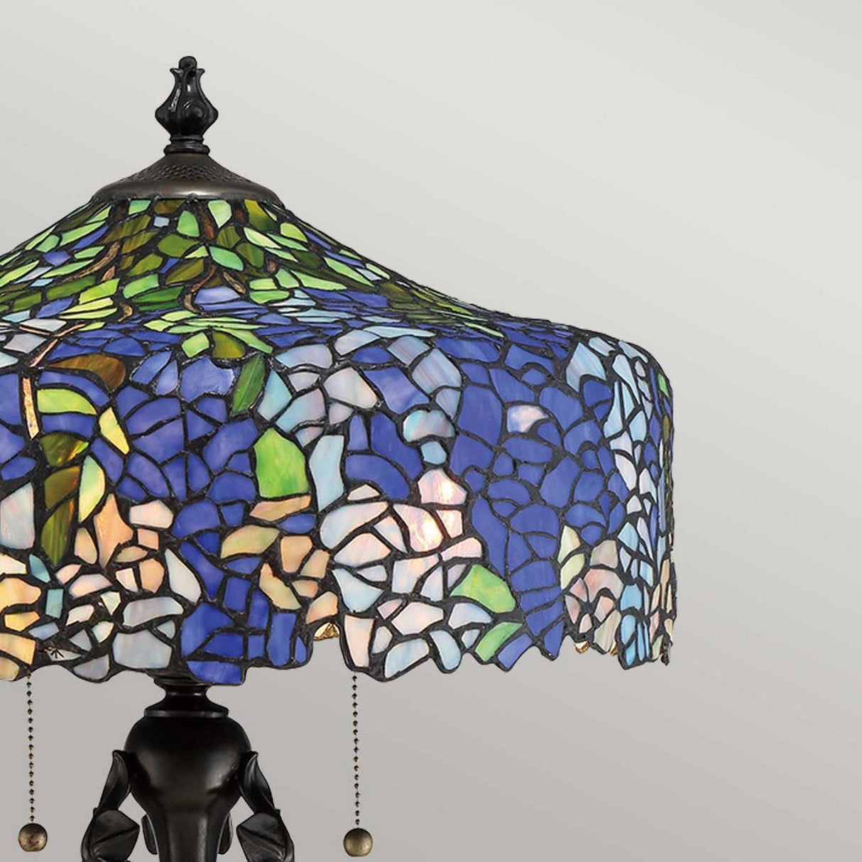 Close-up of the Cobalt 3 Light Tiffany Table Lamp, showcasing a colorful floral hydrangea pattern in shades of blue, green, and white. This lamp features a decorative Vintage Bronze base and pull chains, creating a vintage and artistic ambiance.
