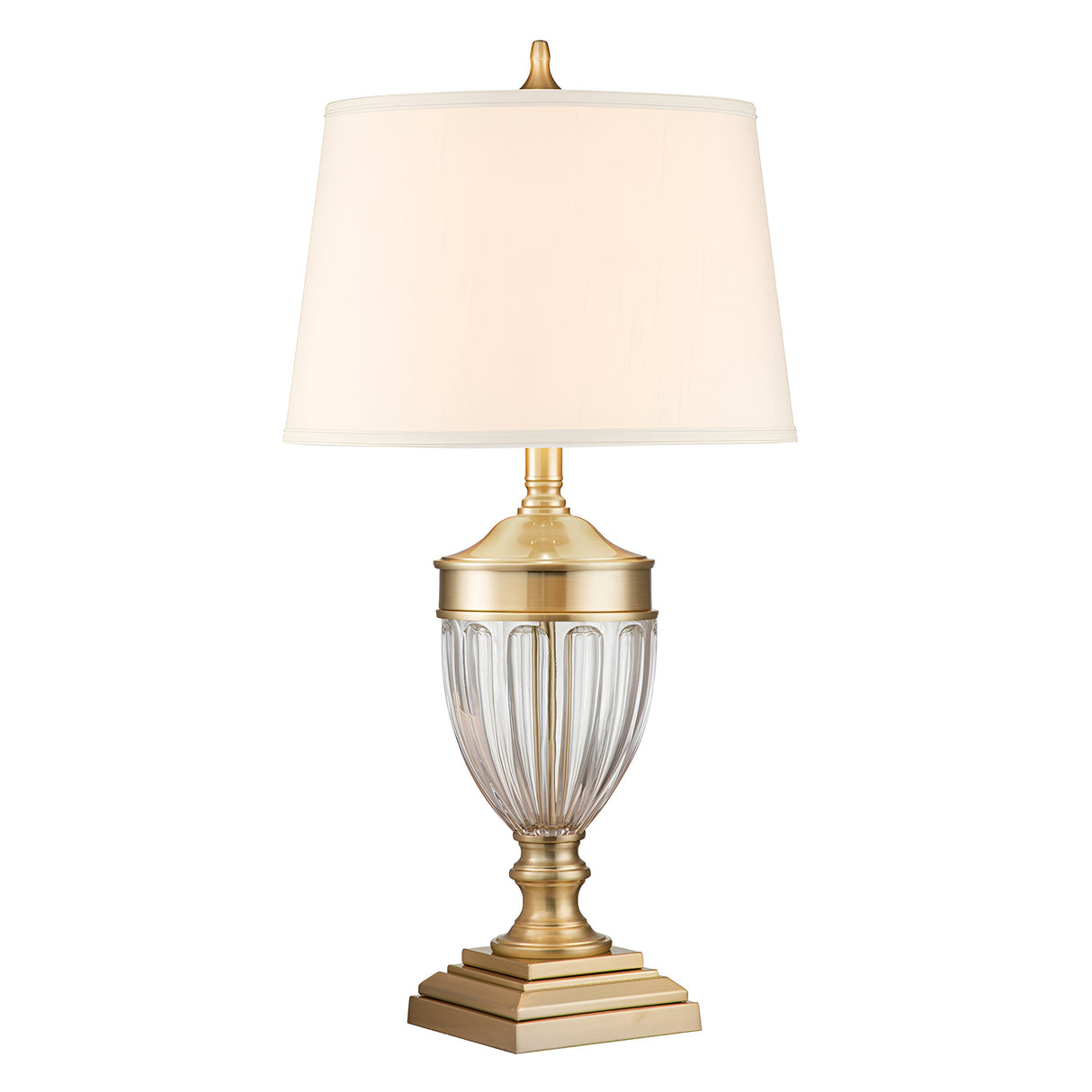 The Dennison 1 Light Table Lamp in brushed brass boasts a fluted base with vertical ribbing and a square pedestal, complemented by a white lampshade, making it a classic and elegant piece of home decor.