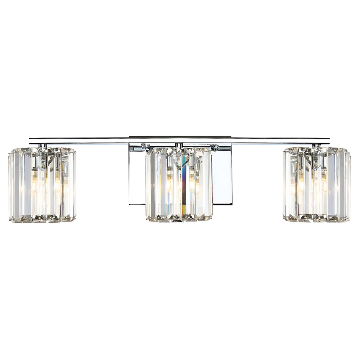 The Divine 3 Light Wall Light - Polished Chrome boasts three cylindrical lamps accented with crystal glass, all mounted on a stylish horizontal polished chrome bar. These lamps display visible bulbs and are complemented by a reflective rectangular backplate, providing an elegant enhancement to any room.
