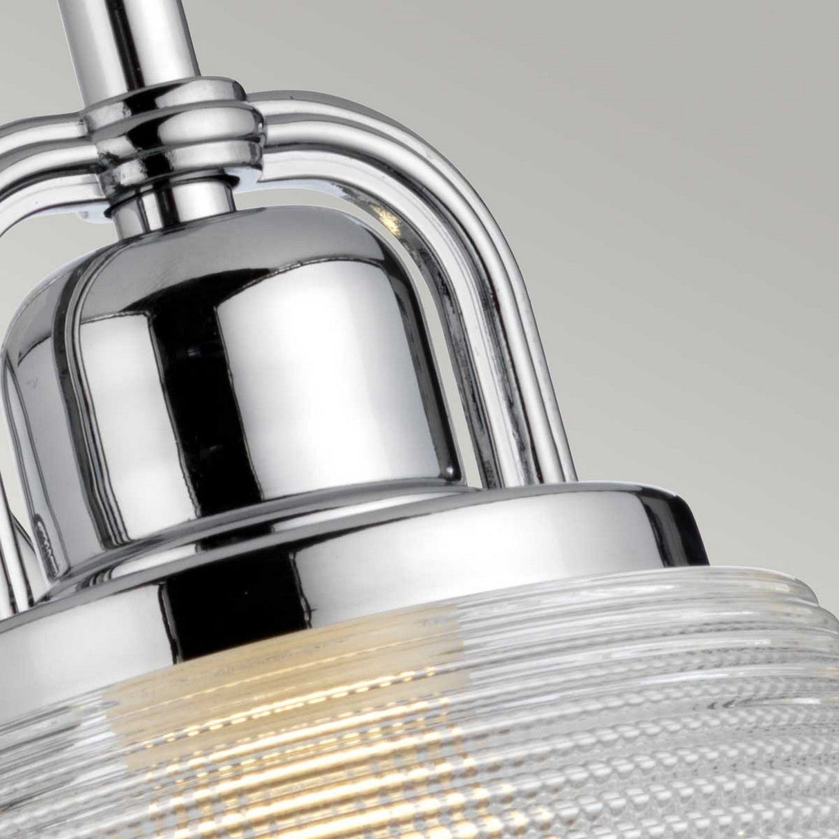 Detailed view of the Dublin 1 Light Wall Light in polished chrome, featuring a ribbed glass shade. Ideal for bathroom lighting, it emits a soft glow against a neutral backdrop.