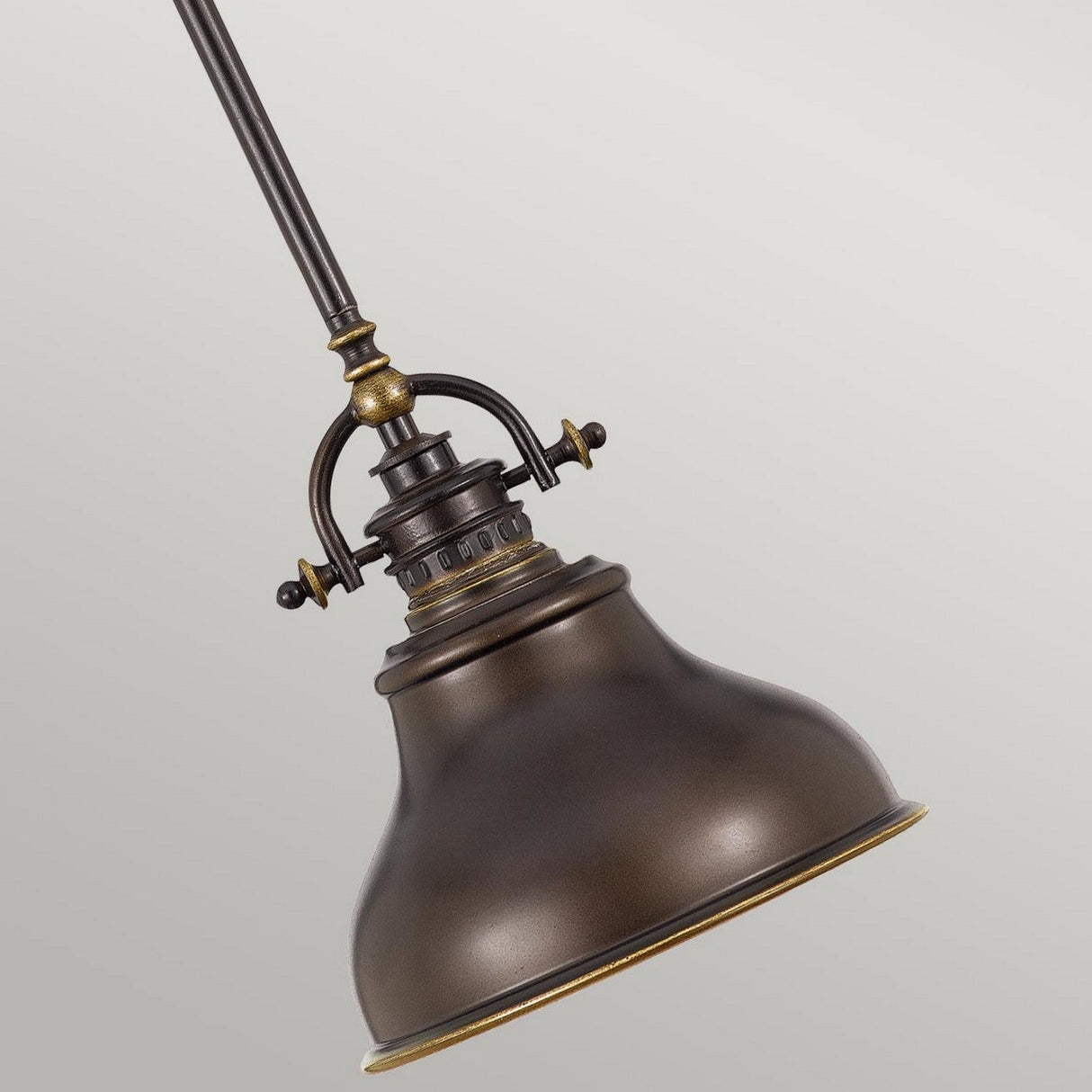 Introducing the Emery 1 Light Mini Pendant in Palladian Bronze, a vintage-inspired piece featuring a wide, bell-shaped shade and decorative metal fittings. This industrial-style gem gracefully hangs from a rod against a plain gray background, embodying classic elegance in any space.