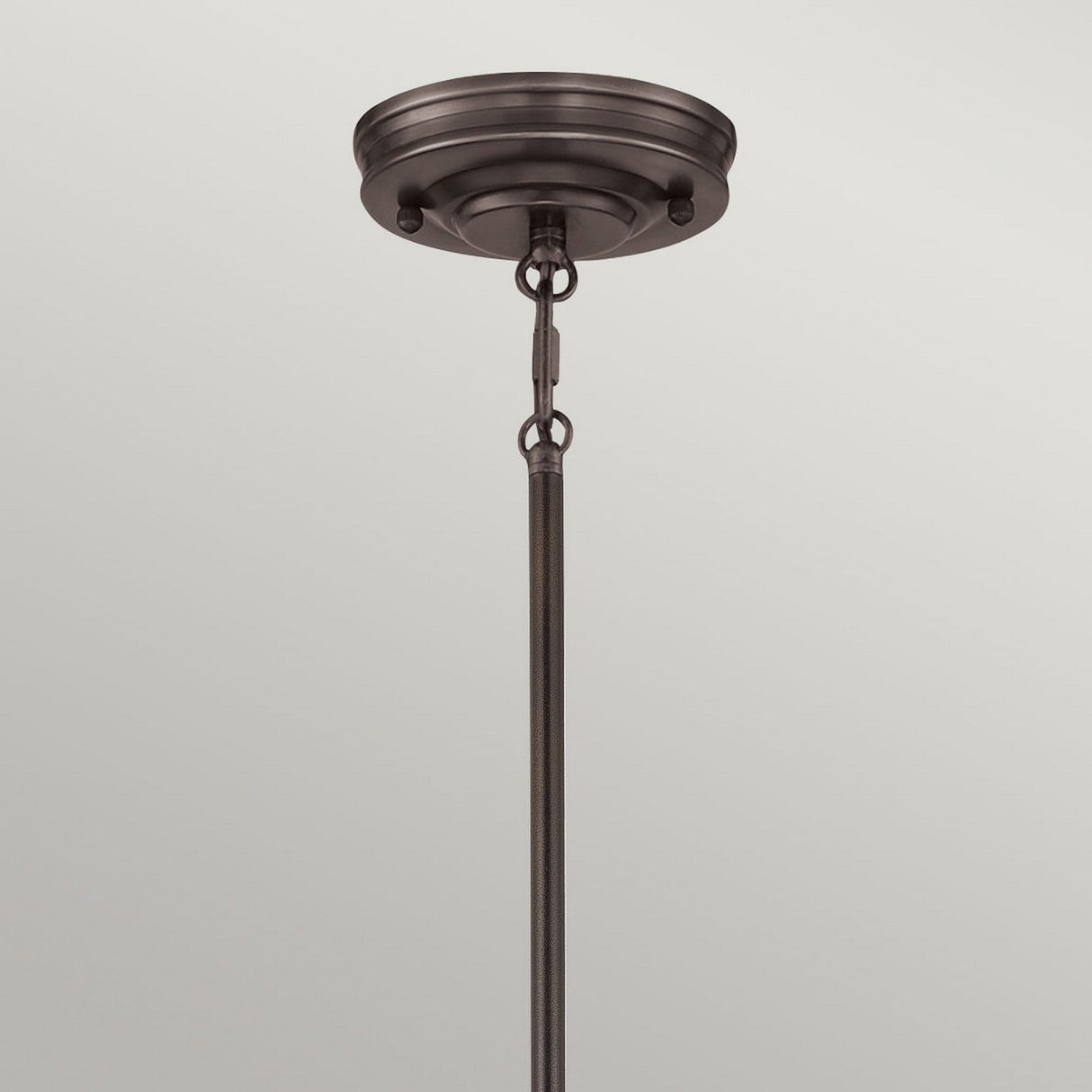 Close-up of the Emery 1 Light Mini Pendant in Palladian Bronze, showcasing its decorative round canopy and rod for hanging fixtures. This vintage-inspired design features a hook and chain detail connecting the rod to the canopy, set against a soft light gray background.