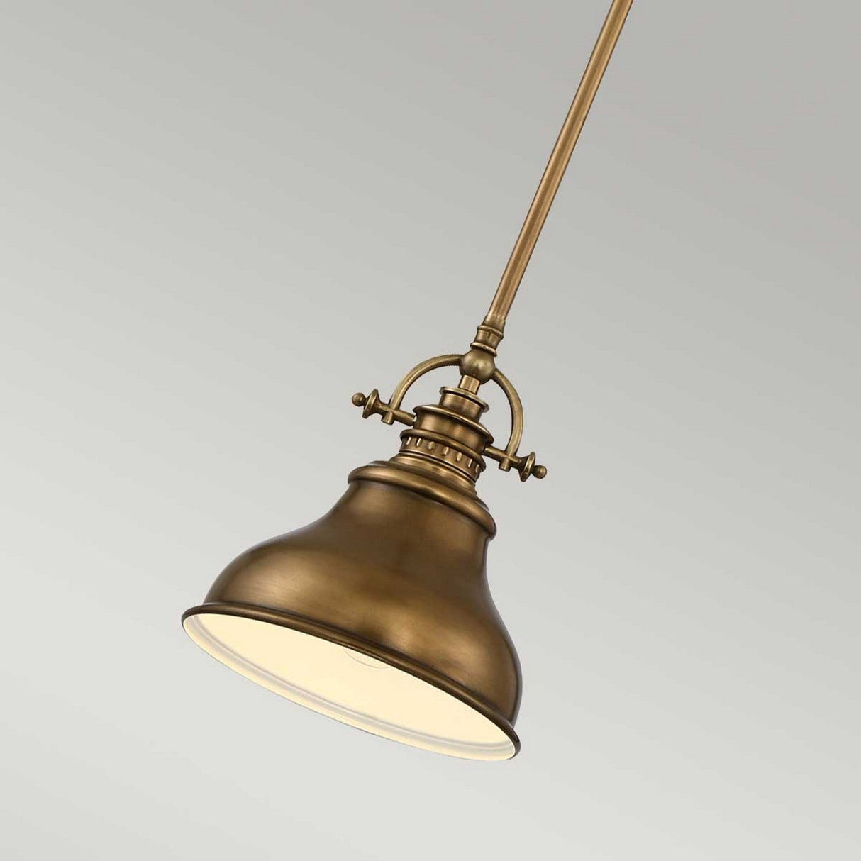 The Emery 1 Light Mini Pendant in Weathered Brass features a dome-shaped shade suspended from a slender rod. Set against a simple, neutral background, this mini pendant highlights its elegant metallic finish and timeless design.