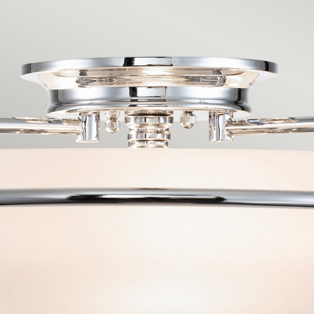 Close-up of the Griffin 3 Light Flush in polished chrome, illustrating its sleek and reflective metallic design as it seamlessly attaches to the ceiling in a contemporary flush mount style.