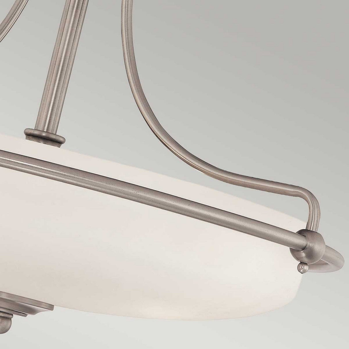 Close-up of the Griffin 4 Light Semi-Flush, showcasing its frosted white glass shade and sleek metal frame with an antique nickel finish. This fixture embodies a contemporary and minimalist design, highlighting clean lines and smooth curves while delivering soft ambient lighting against a plain background.