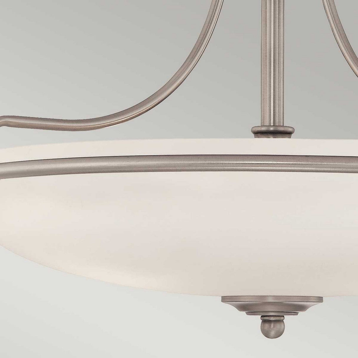 Close-up of the Griffin 4 Light Semi-Flush in Antique Nickel, showcasing its modern design with a frosted glass bowl shade and metal accents, complemented by curved metal arms extending upward to enhance ambient lighting.