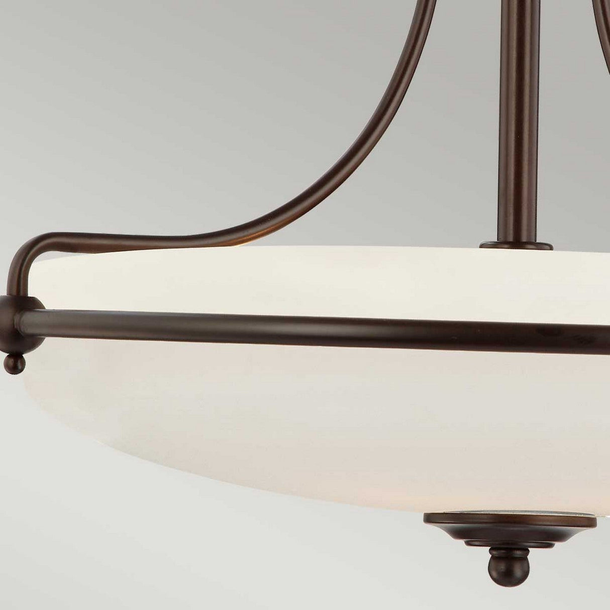 Close-up of the Griffin 4 Light Semi-Flush - Palladian Bronze, a modern ceiling light fixture featuring an etched glass shade with a dark Palladian Bronze frame. The design includes curved metal arms and a small finial at the bottom, set against a plain background.