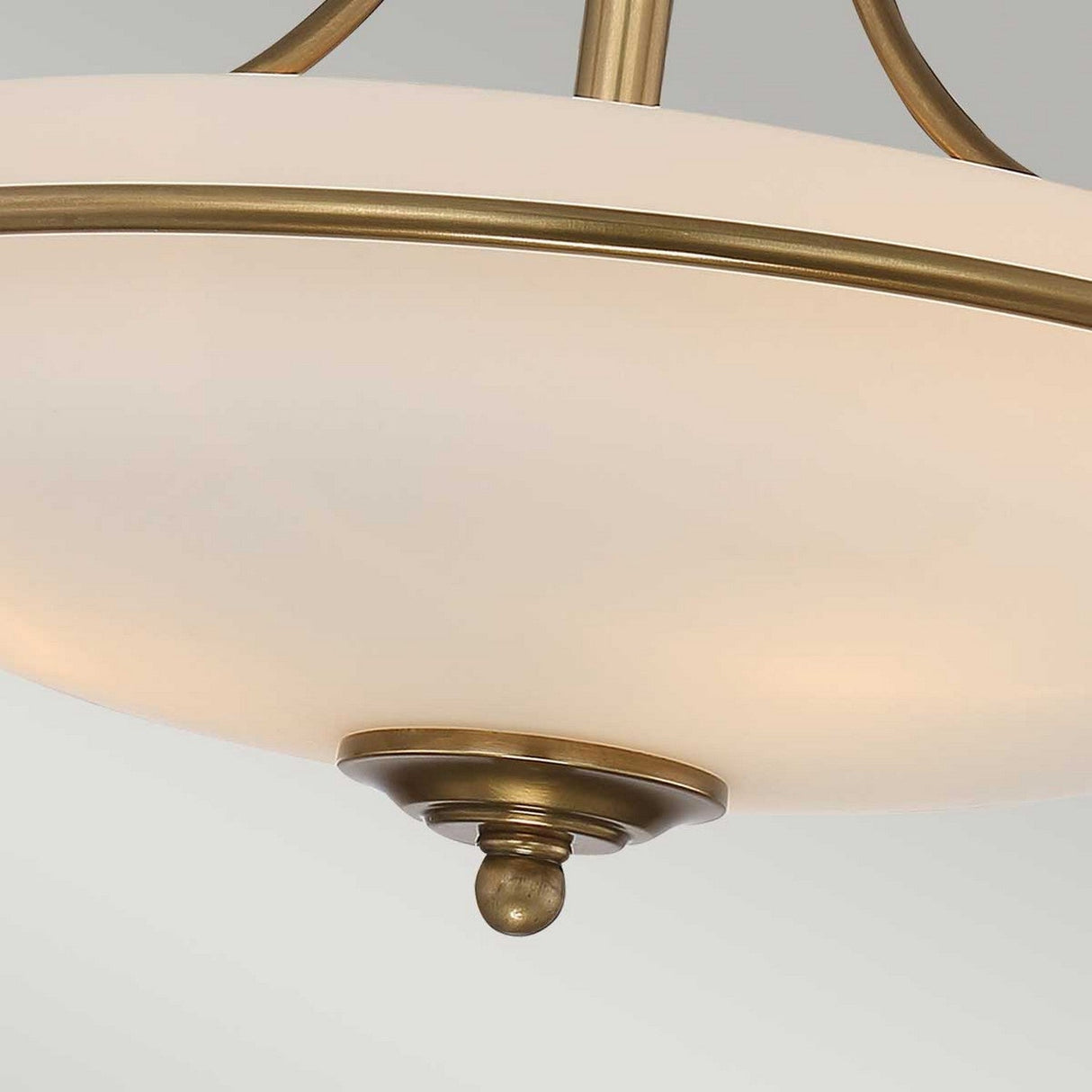 Close-up of the Griffin 3 Light Semi-Flush in weathered brass, featuring a frosted glass dome accented with weathered brass details and a central decorative brass knob at the base. The classic, elegant design is enhanced by its etched white shade.