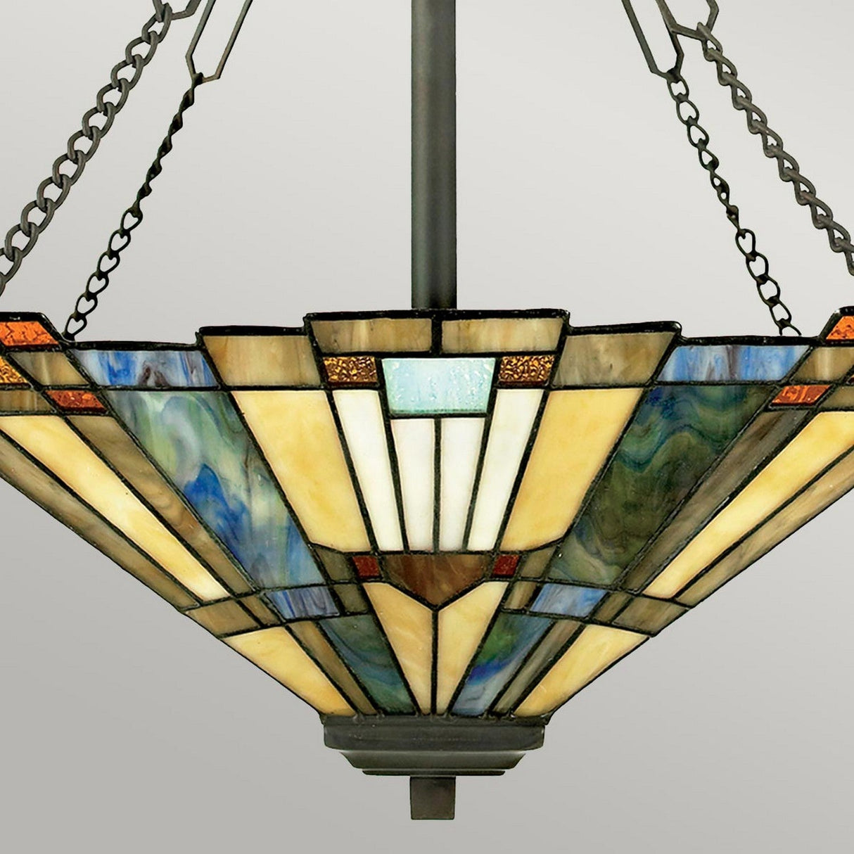 Discover the Inglenook 3 Light Large Tiffany Pendant in Valiant Bronze, featuring a stunning stained glass chandelier with geometric patterns in shades of blue, green, and cream. This Art Deco style piece hangs from chains connected to a central metal rod and is beautifully complemented by its valiant bronze accents.