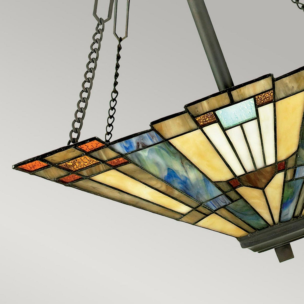 The Inglenook 3 Light Large Tiffany Pendant - Valiant Bronze features a captivating geometric design with stained glass panels in blue, green, yellow, and red that glisten brilliantly. It hangs gracefully from a valiant bronze fixture complete with chain links against a gray background.