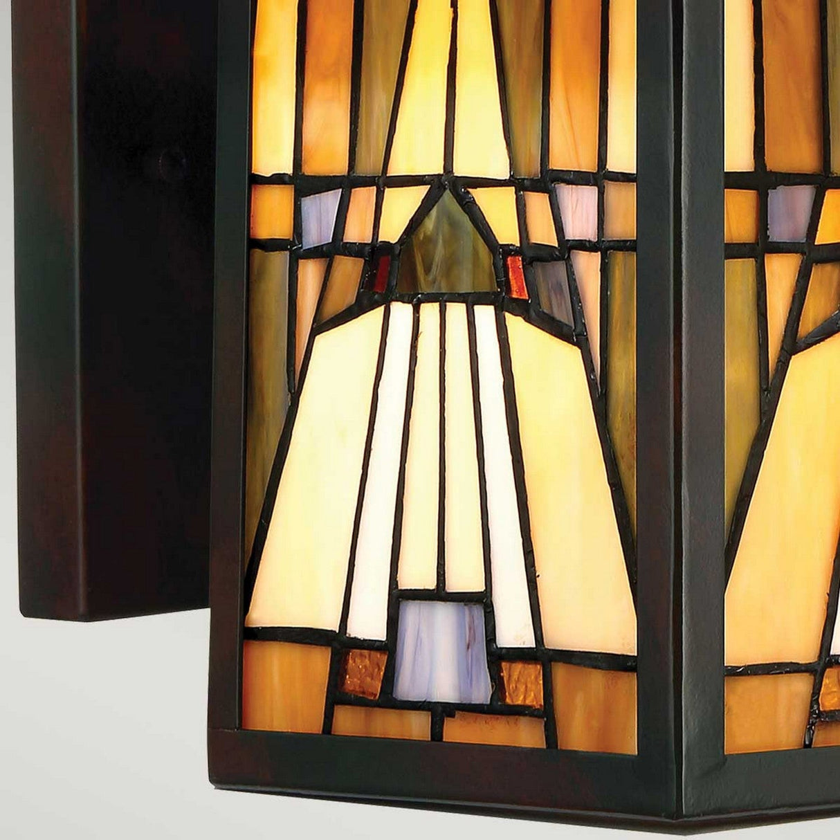 A detailed view of the Inglenook Outdoor 1 Light Medium Wall Lantern in Valiant Bronze showcases geometric patterns in rich shades of amber, cream, and brown. Echoing the Arts & Crafts style, the design features symmetrical shapes outlined in black, giving it a classic and sophisticated look.