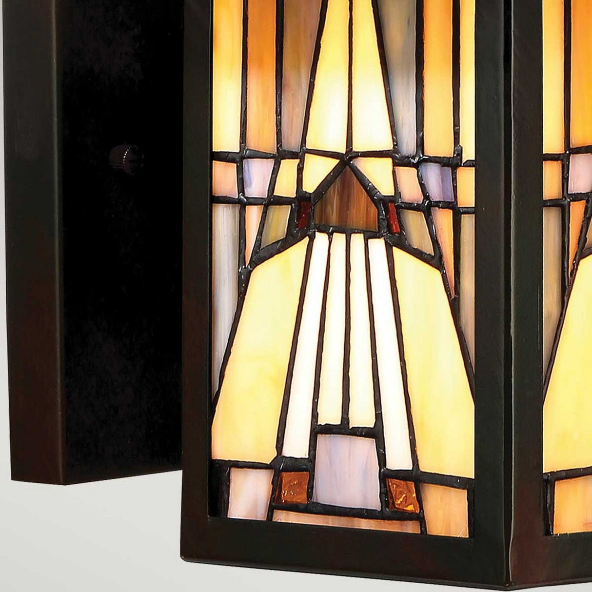The Inglenook Outdoor 1 Light Small Wall Lantern in Valiant Bronze showcases an Arts & Crafts style design with geometric patterns in amber, beige, and gray hues, framed by dark metal. Its symmetrical lines and shapes offer a decorative and artistic appeal reminiscent of a stained glass window.