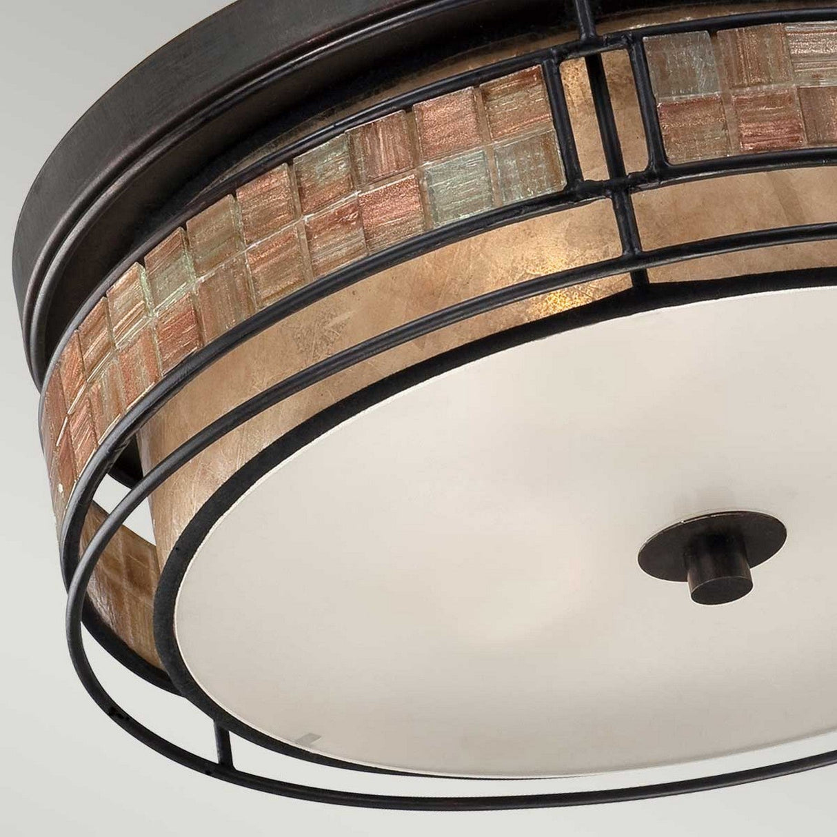The Laguna 3 Light Large Flush - Renaissance Copper features a circular design with a frosted glass center. Its frame is embellished with a mosaic tile stripe in earthy tones and Renaissance Copper accents, elegantly bordered by dark metal bands.