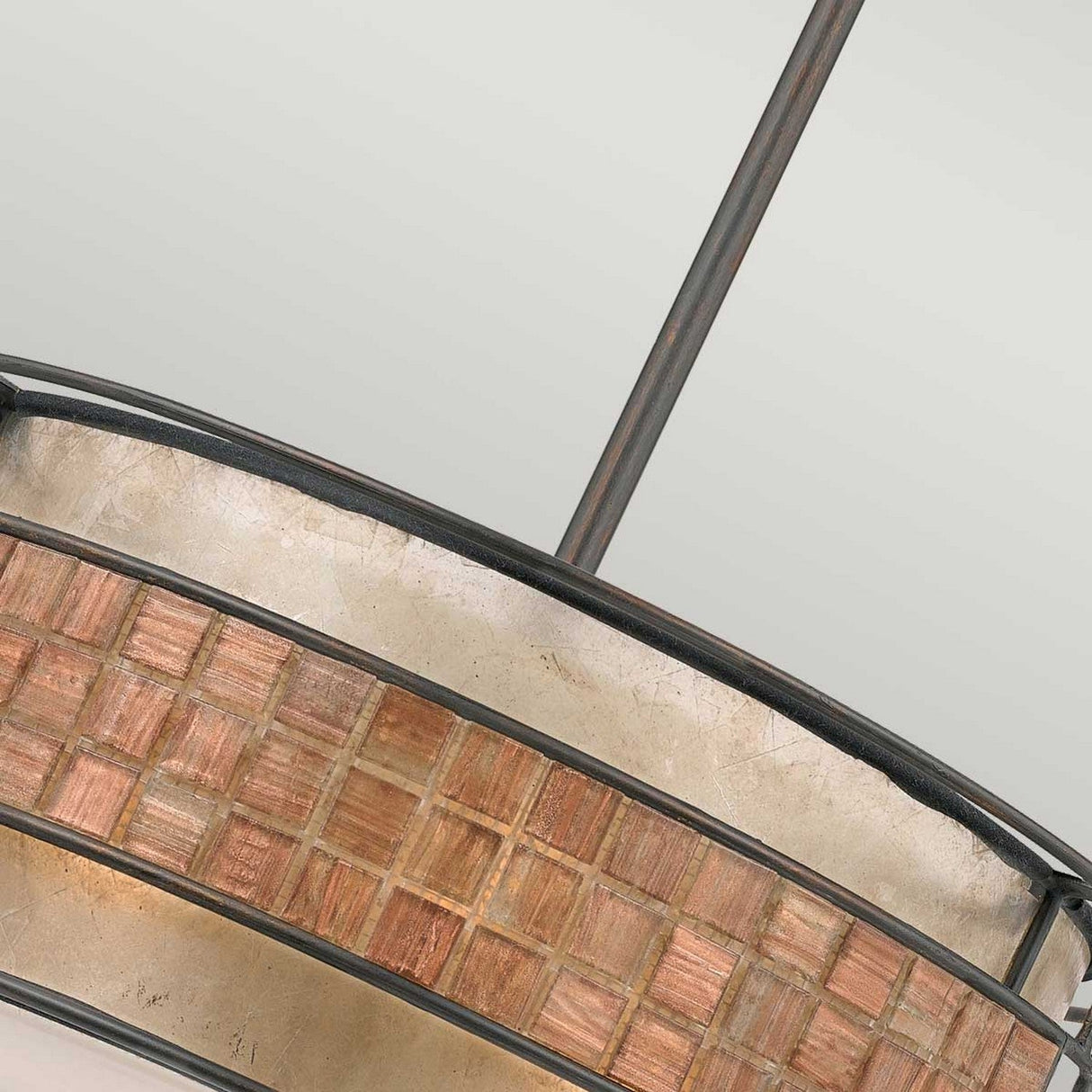 Close-up of the Laguna 4 Light Chandelier - Renaissance Copper, featuring a circular design with textured metal and wood. The fixture showcases a grid-like pattern, complemented by a taupe mica shade, elegantly suspended from a metal rod against a plain white ceiling.