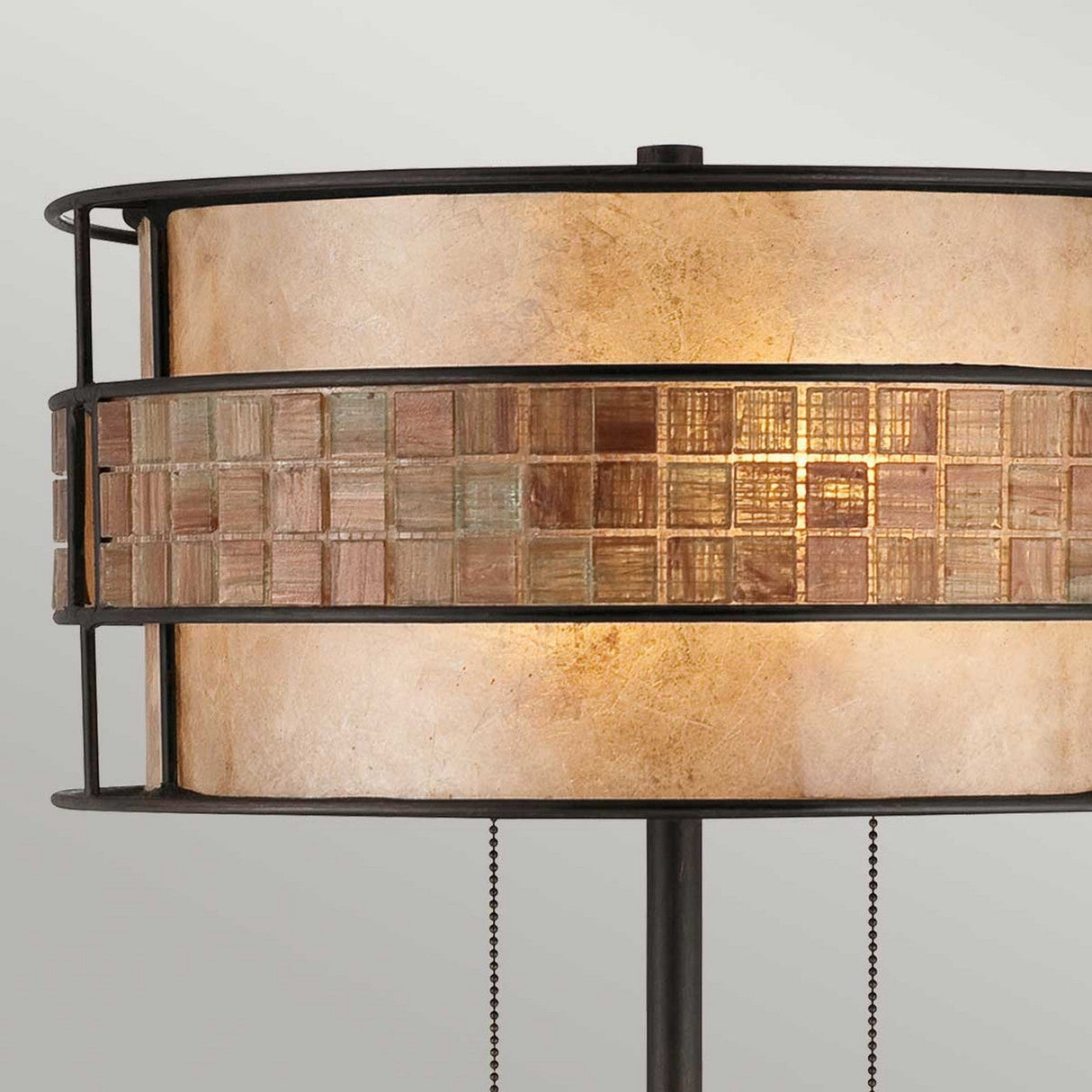 The Laguna 2 Light Table Lamp - Renaissance Copper highlights a cylindrical mosaic tile design in earthy tones. It is beautifully complemented by a taupe mica shade, while pull chain switches add a touch of classic elegance. Positioned against a neutral gray background, the lamp creates an elegant display.