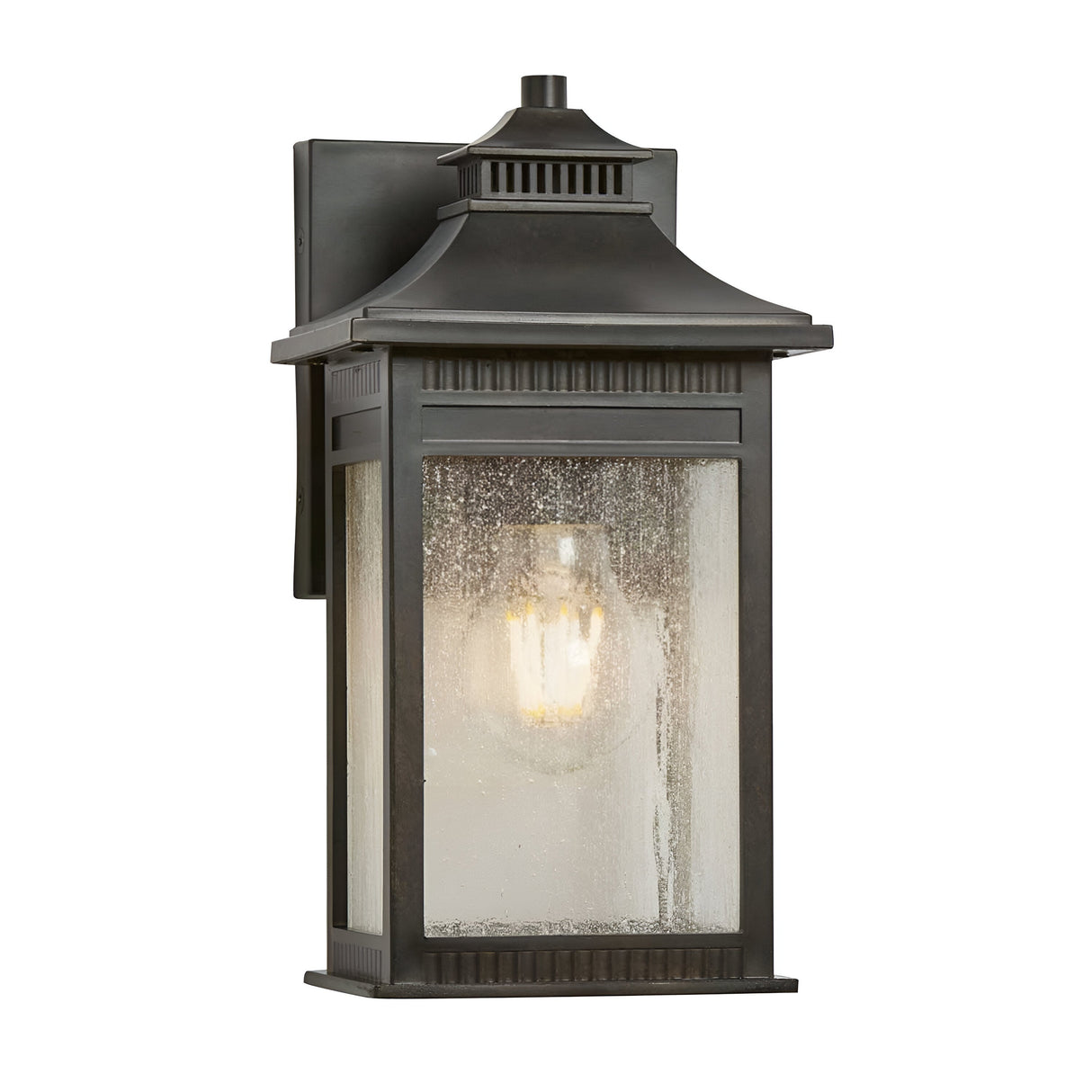 The Livingston Outdoor 1 Light Small Wall Lantern in Imperial Bronze showcases a classic rectangular design with clear seedy glass panels, complemented by a warm-lit bulb inside to enhance its elegance against the white background.