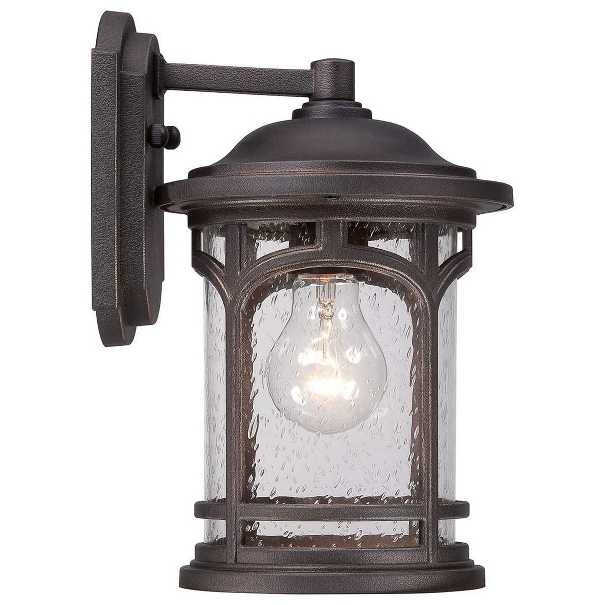 The Marblehead Outdoor 1 Light Small Wall Lantern in Palladian Bronze features a rustic design with a dark metal frame and clear seedy glass panels. It elegantly displays a visible glowing light bulb inside, mounted on a square base with an arm extending from the wall.